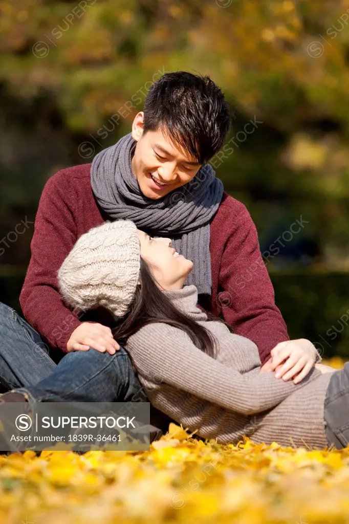 Sweet college couple looking into each other's eyes under the autumn sunshine