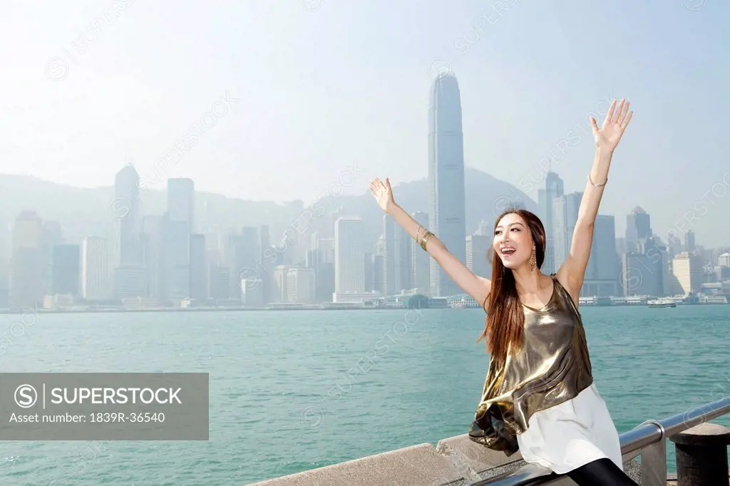 Fashionable young woman enjoying the beautiful scenery of Victoria Harbor, Hong Kong