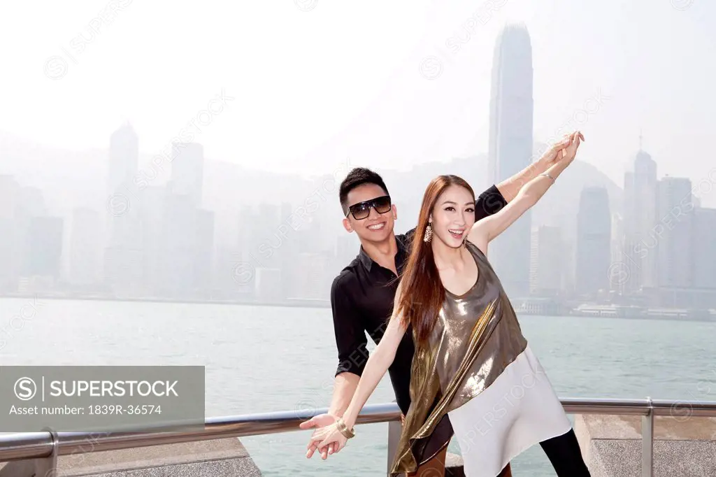 Happy young couple appreciating the spectacular view of Victoria Harbor, Hong Kong