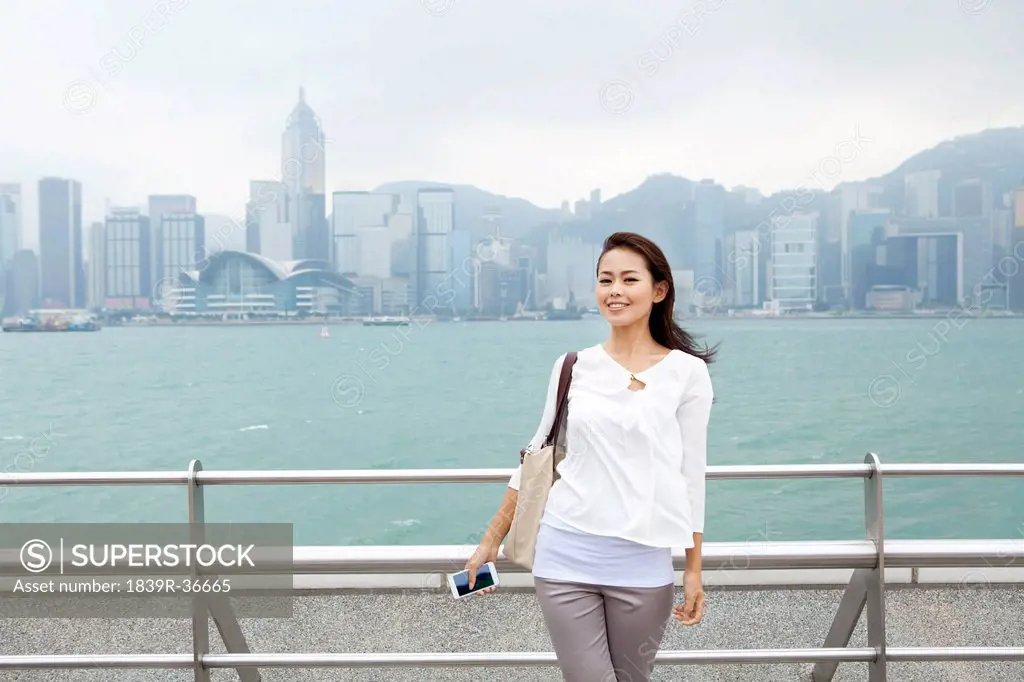 Happy young woman enjoying the beautiful scenery of Victoria Harbor, Hong Kong
