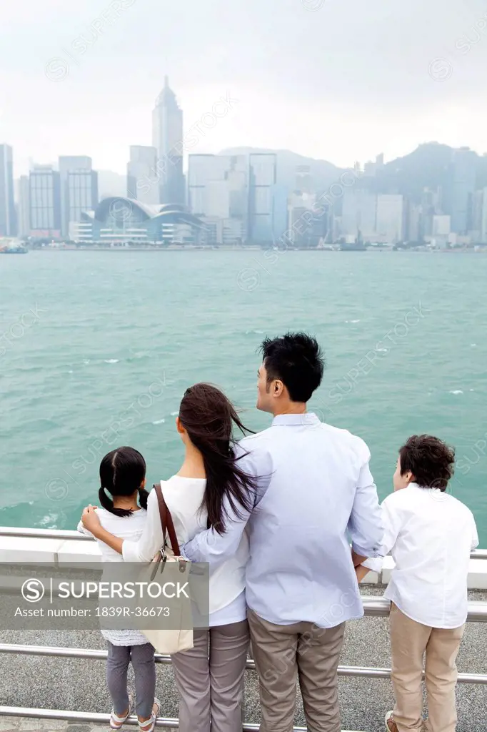 Young family enjoying the beautiful scenery of Victoria Harbor, Hong Kong