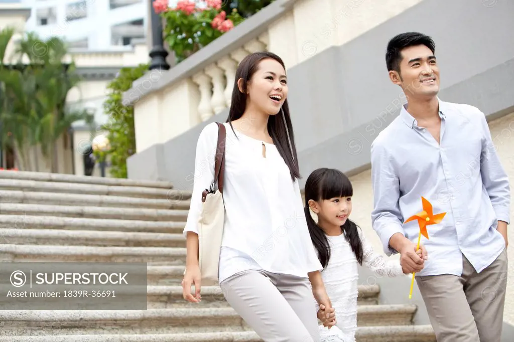 Cheerful young family walking down steps in Hong Kong