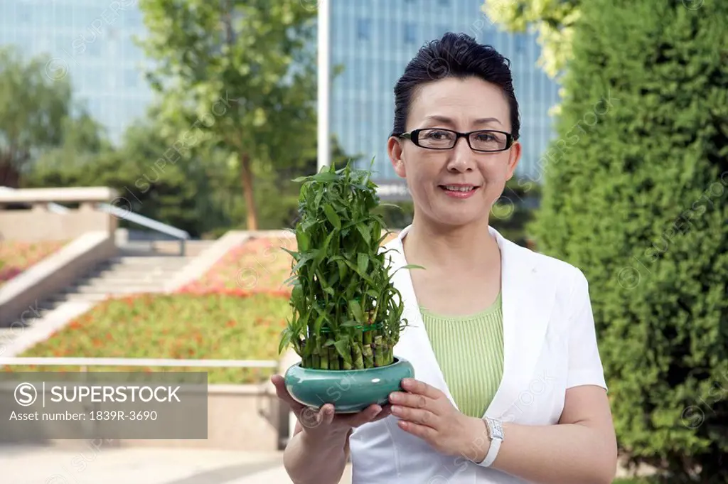 Portrait Of Woman Holding A Plant
