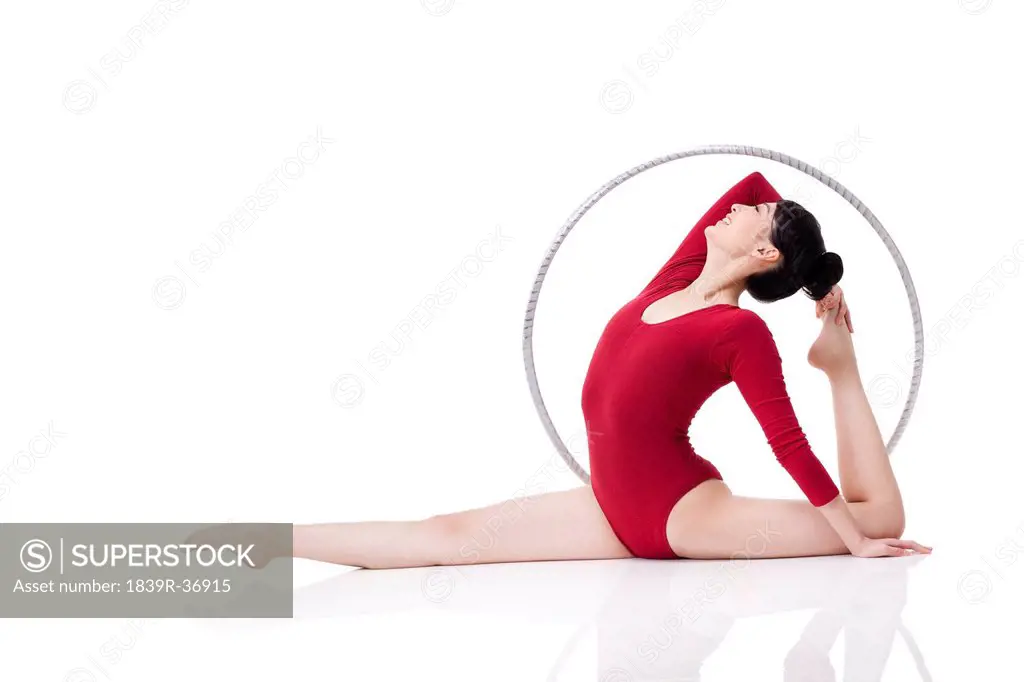 Female rhythmic gymnast performing with hoop