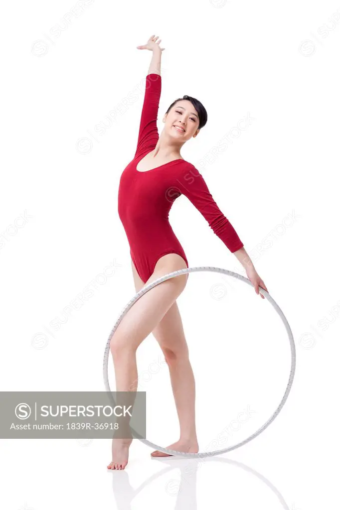 Female rhythmic gymnast performing with hoop