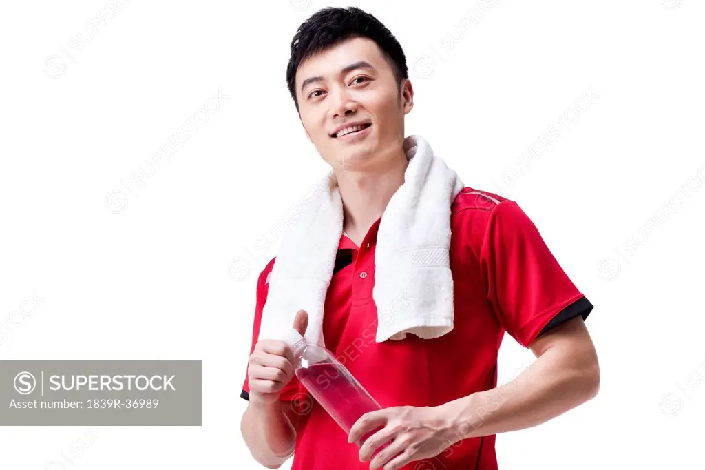 Male athlete with towel and bottled water