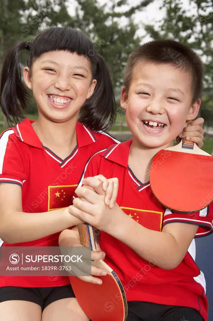 Children Sitting On Ping Pong Table Smiling