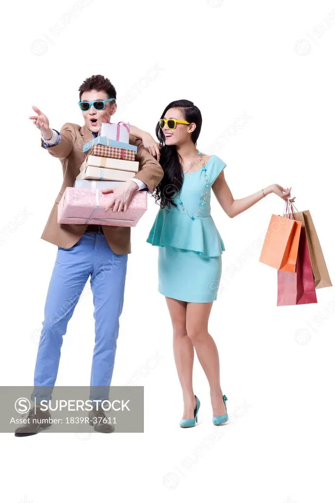 Stylish couple with shopping bags looking at view