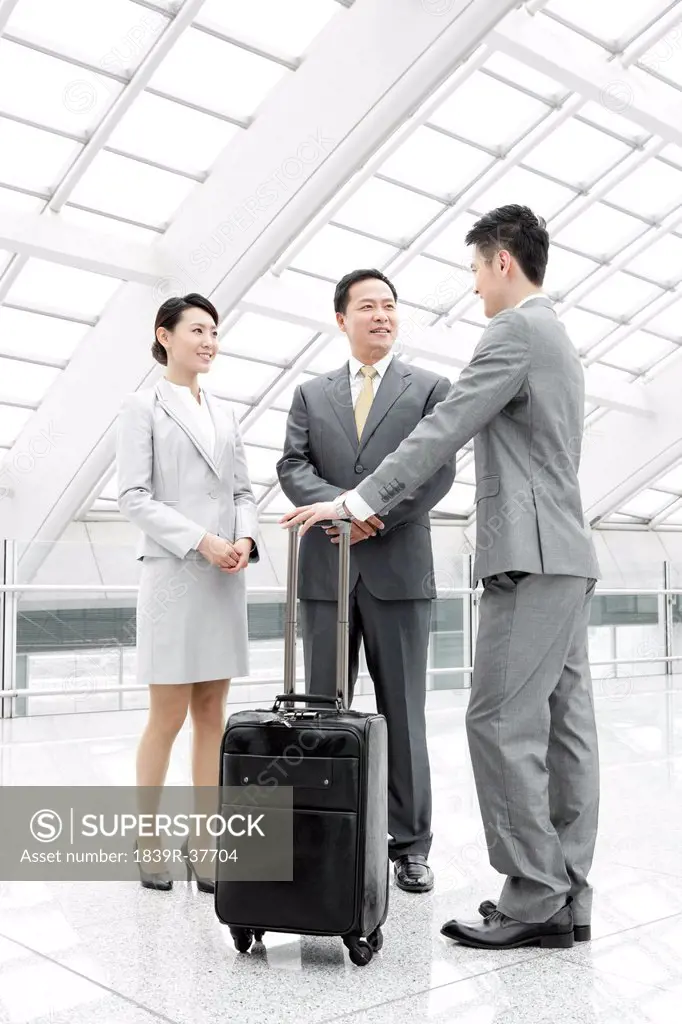 Business partners having conversation in airport lobby