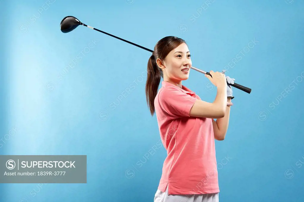 Woman Swinging Golf Club