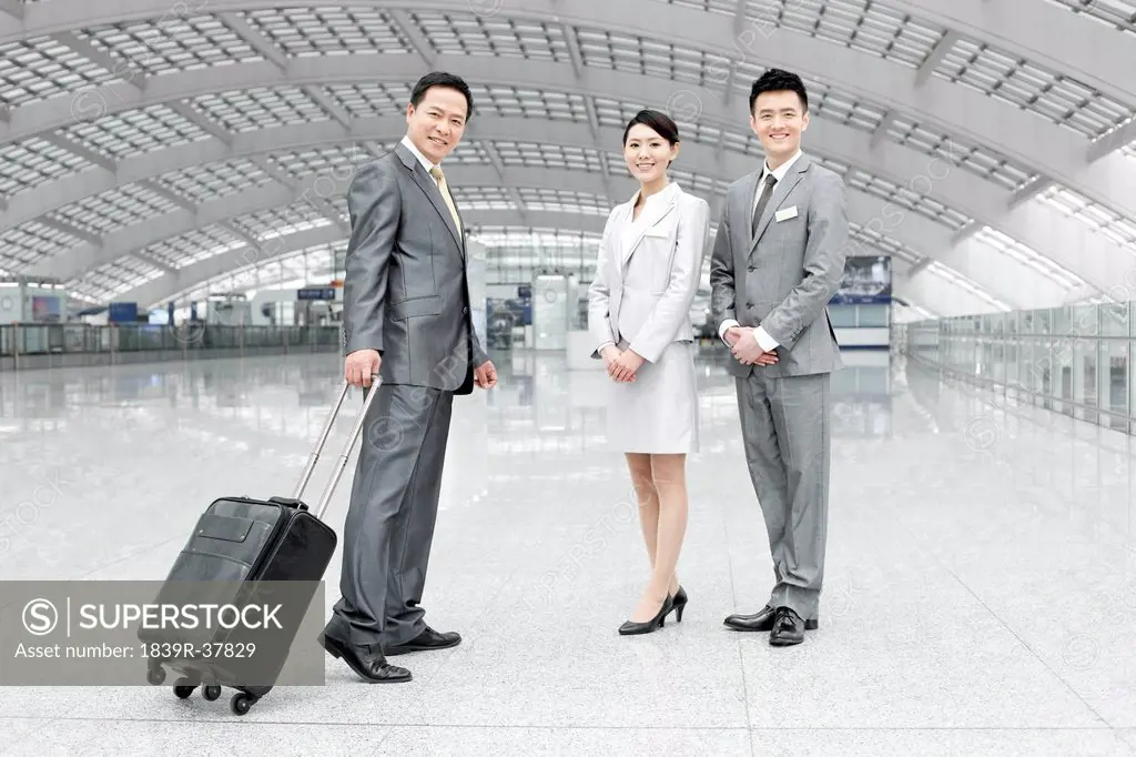 Young business partners with name tags greeting guest at the airport