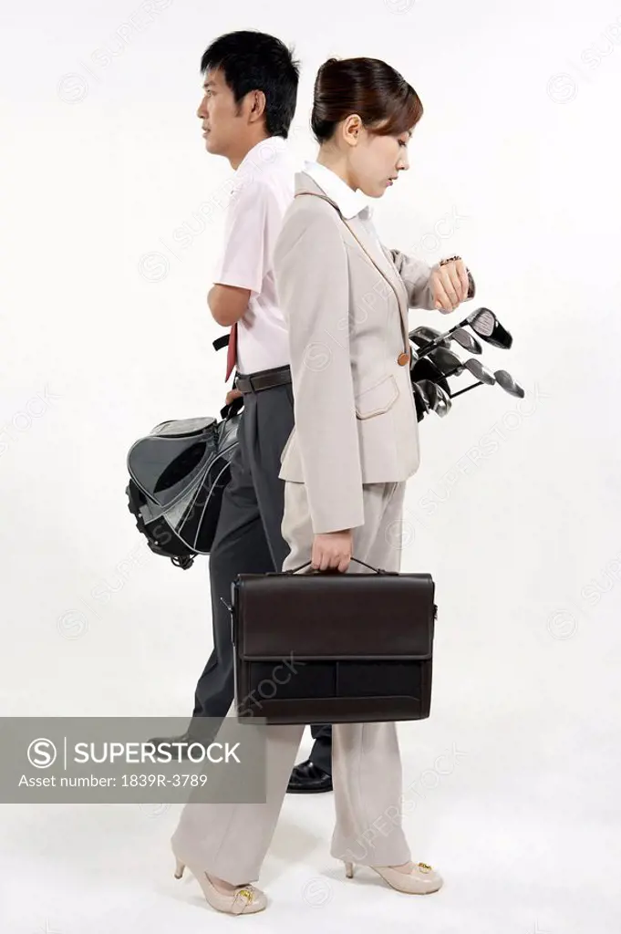 Businessman And Businesswoman With Golfclubs