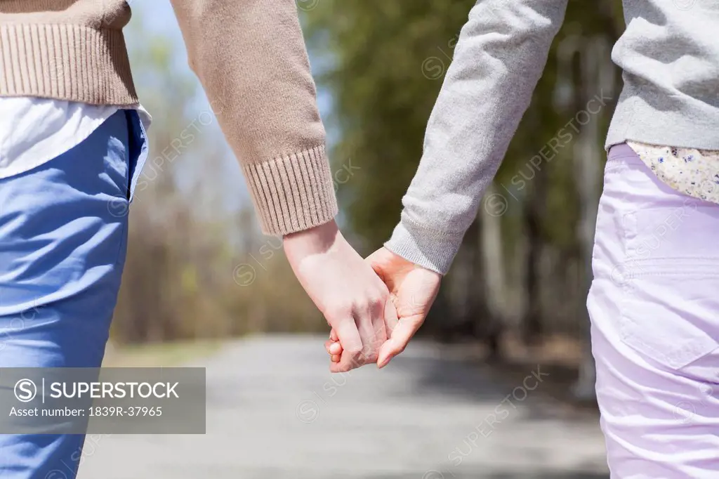 Close up of young couple holding hands
