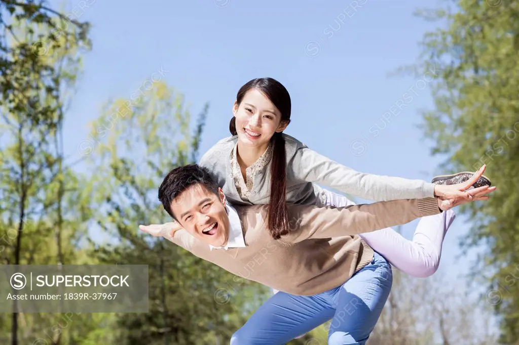 Excited young couple pretending to be a plane