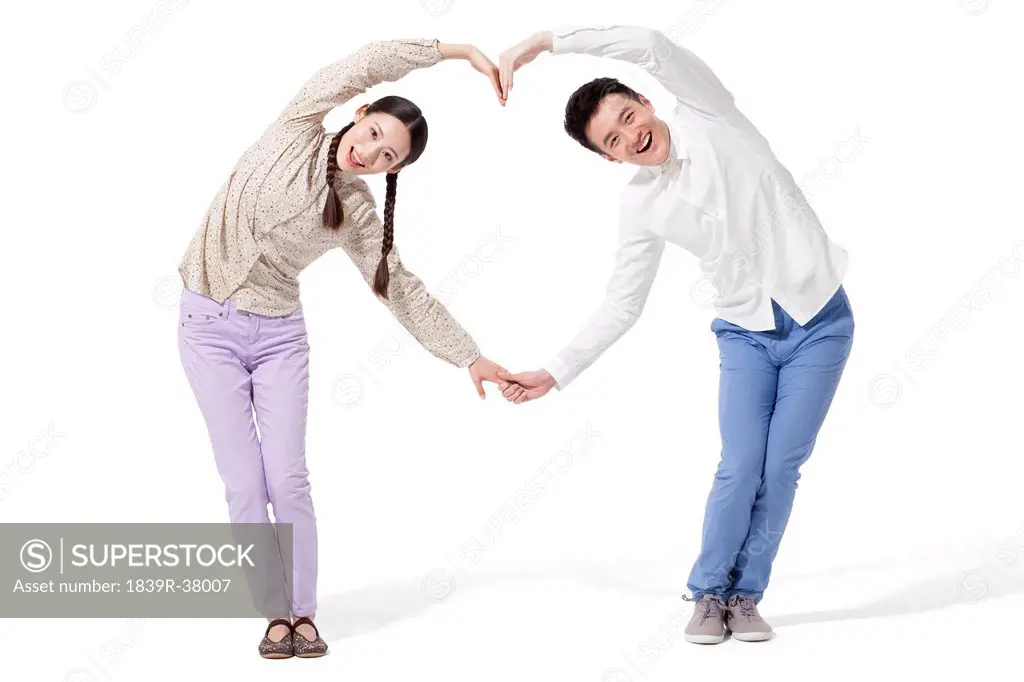 Retro couple making heart shape with their arms