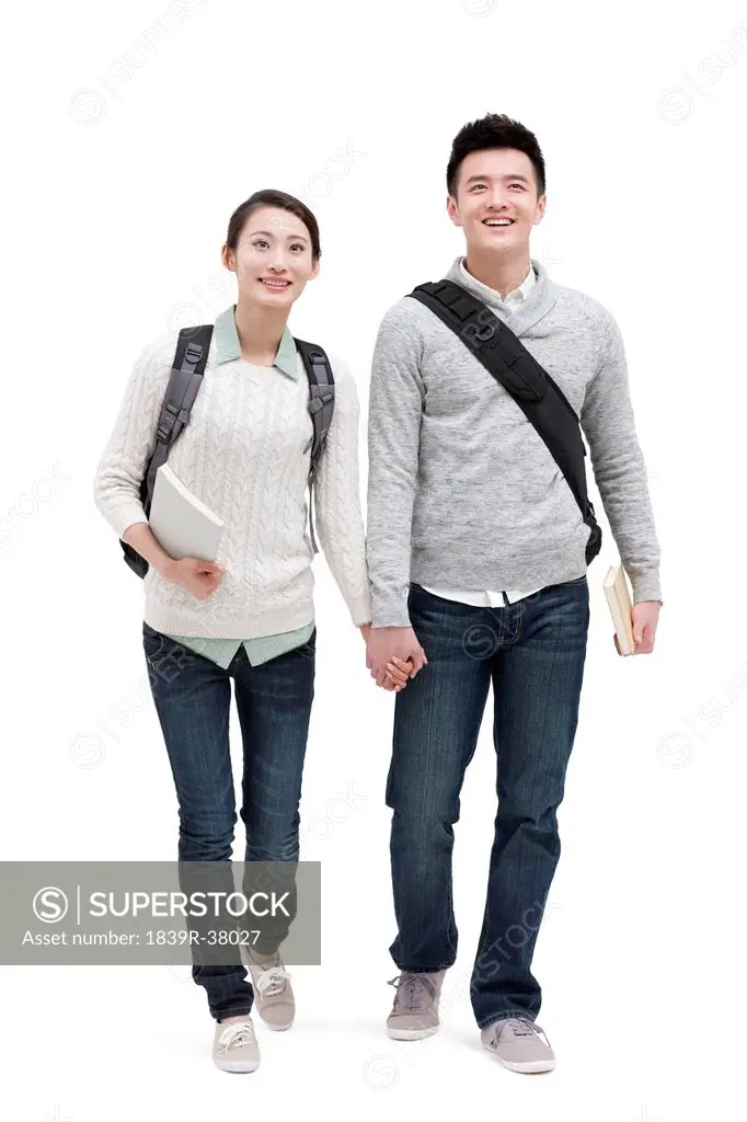 Happy college couple walking hand in hand