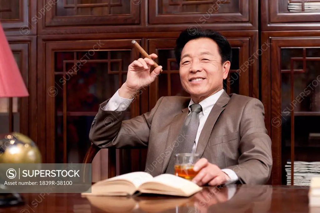 Successful businessman enjoying cigar