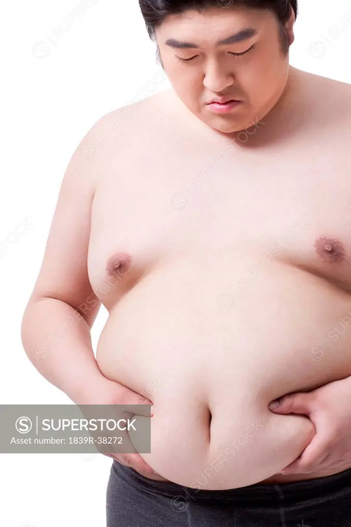 Overweight man in underpants pinching stomach