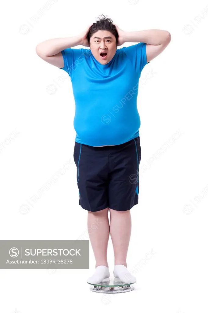 Overweight man on scale, shocked
