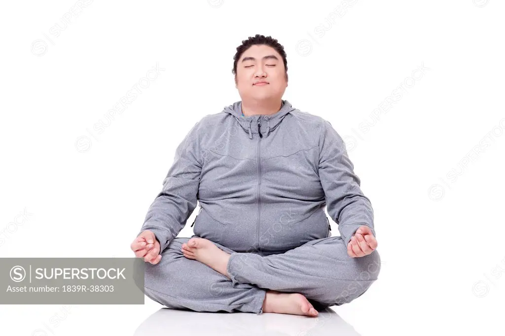 Happy fat man meditating, cross-legged