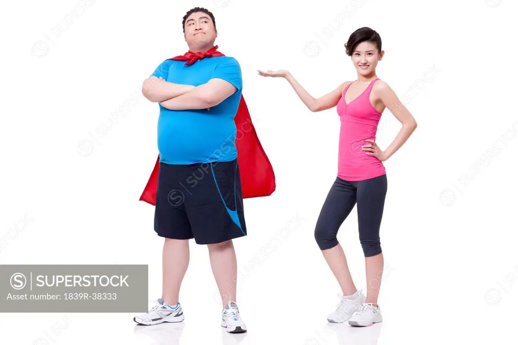 Happy young woman introducing fat superhero