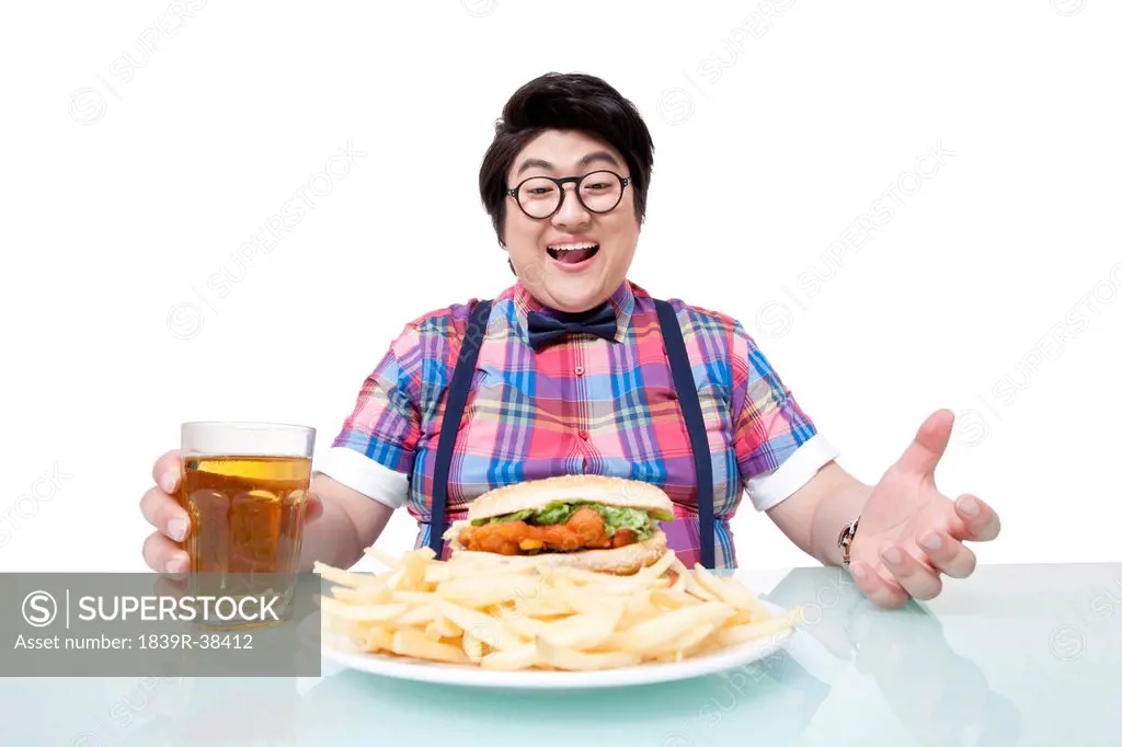 Overweight young man eating fast food