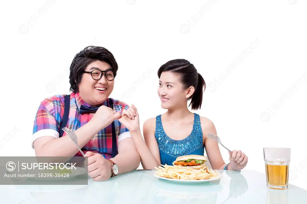 Overweight young man and young woman making a finger oath on dieting