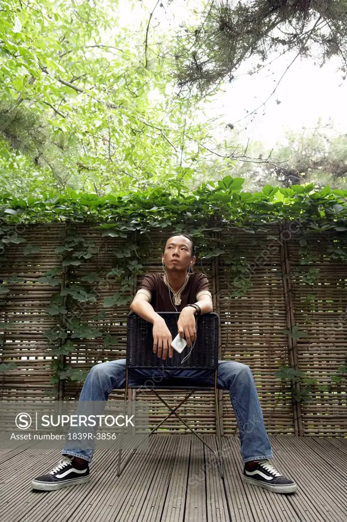 Young Man Looks To The Sky As He Sits On A Backwards Chair