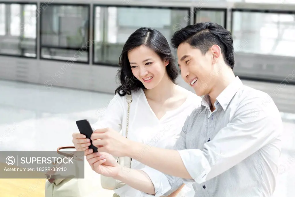 Young couple with mobile phone at subway station