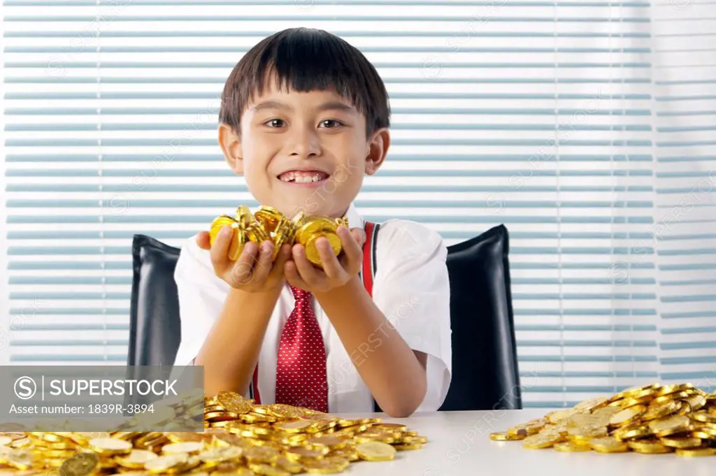 Young Boy With Gold Coins Smiling Happily