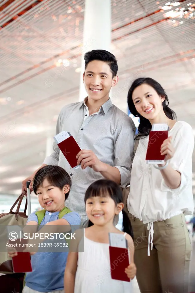 Happy family with flight tickets and passports at the airport