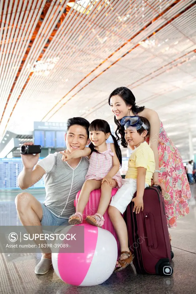 Cheerful family photographing at the airport