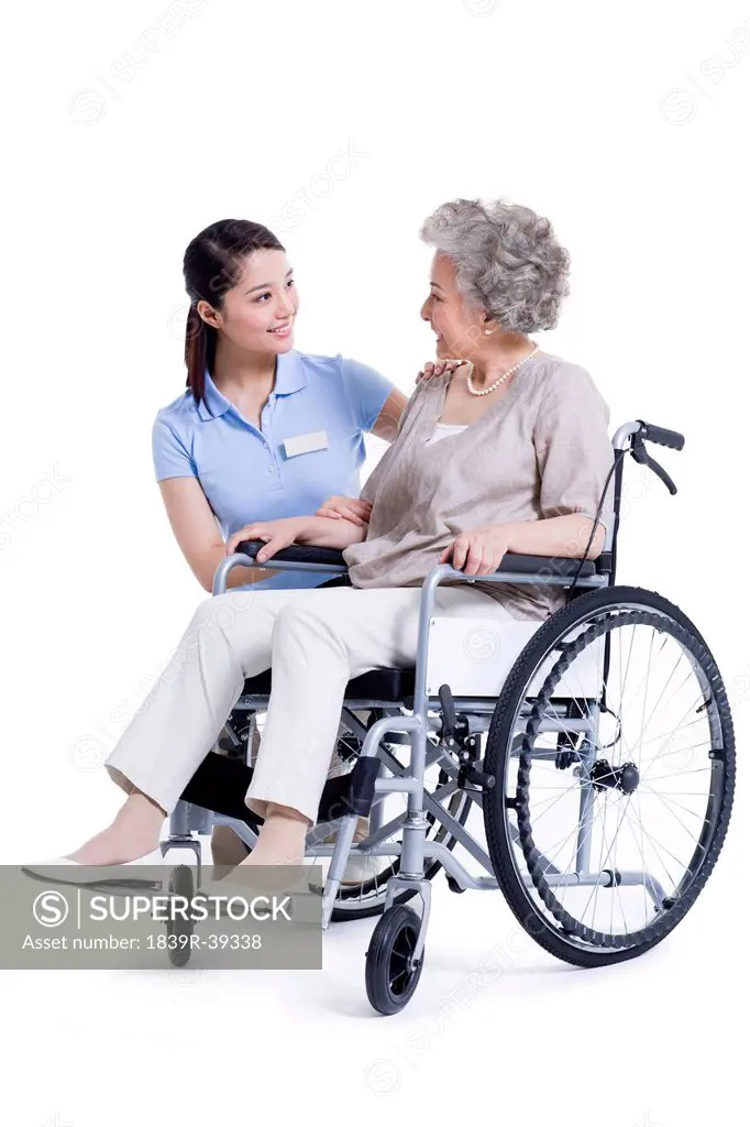Female nursing assistant taking care of senior in wheelchair