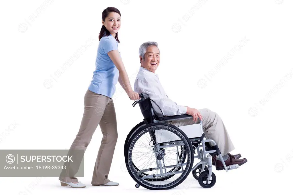 Female nursing assistant taking care of senior in wheelchair