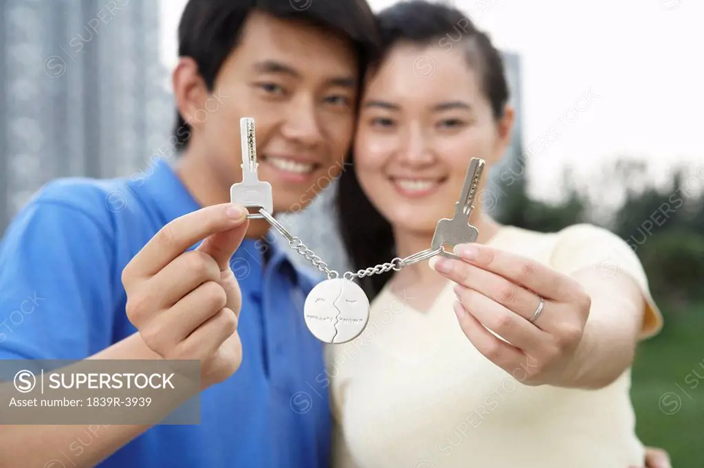 Man And Woman Holding Keys And Smiling