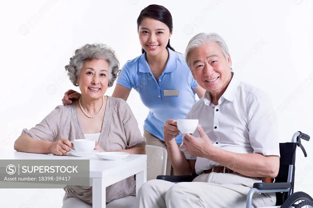 Seniors having a coffee break with nursing assistant