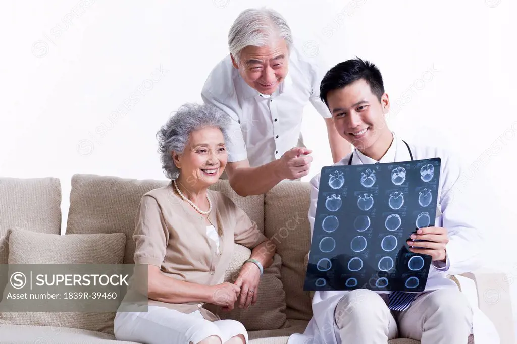 Doctor explaining X-ray image to senior couple