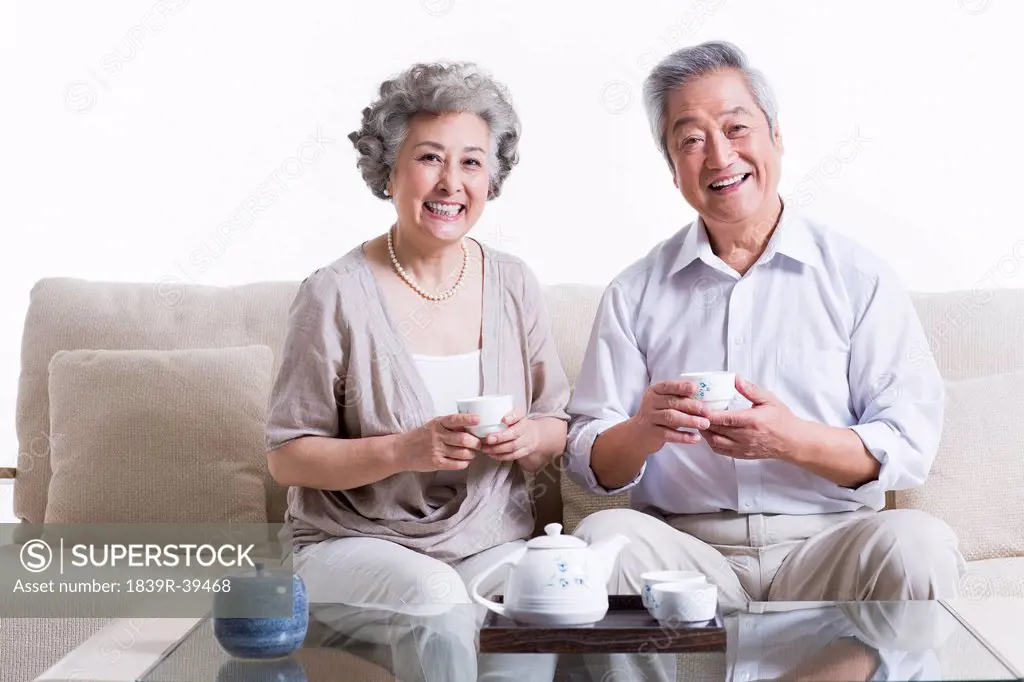 Cheerful senior couple having tea