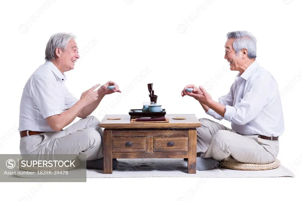 Male senior friends chatting over tea