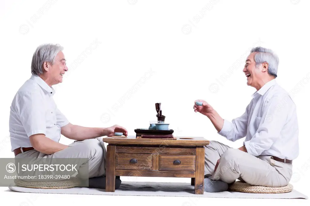 Male senior friends chatting over tea