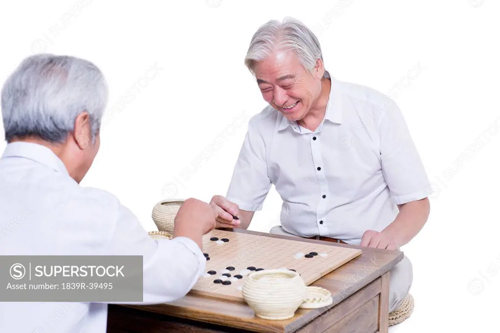 Male senior friends playing go