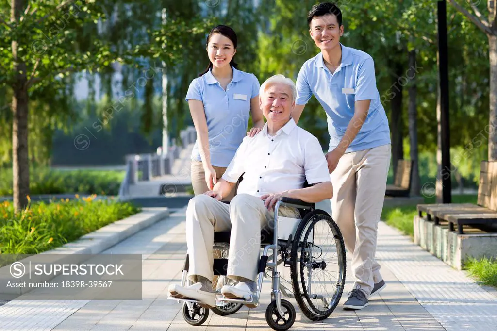 Wheelchair bound man with nursing assistants