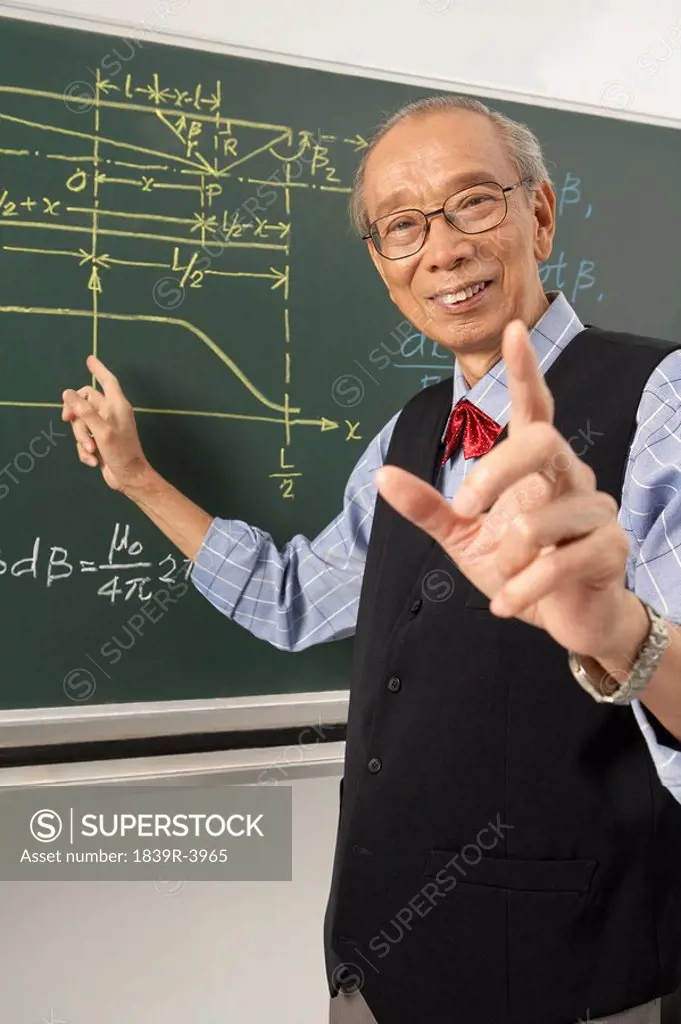 Teacher Pointing To Blackboard