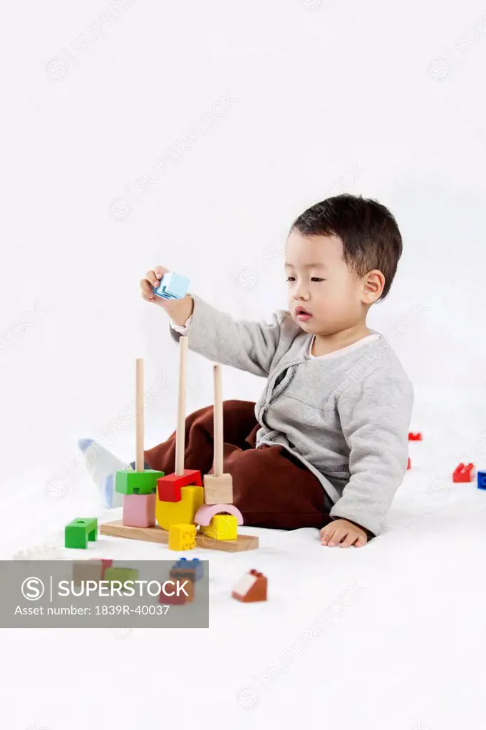 Cute little boy piling up building blocks