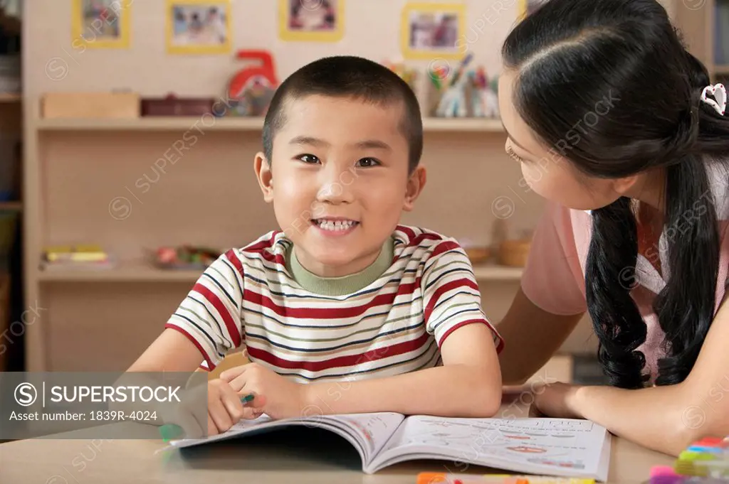 Teacher And Young Child Reading A Book
