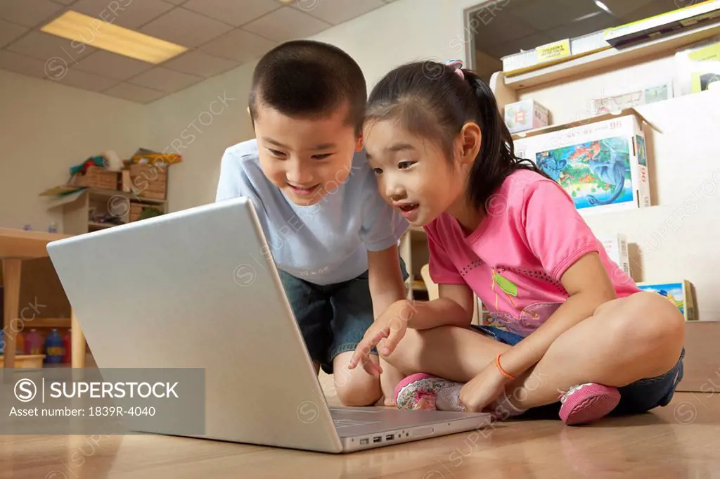 Young Children Smiling At Computer