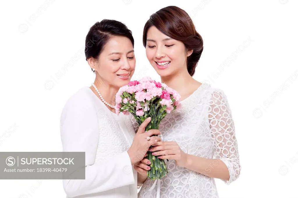 Happy daughter giving flowers to mother