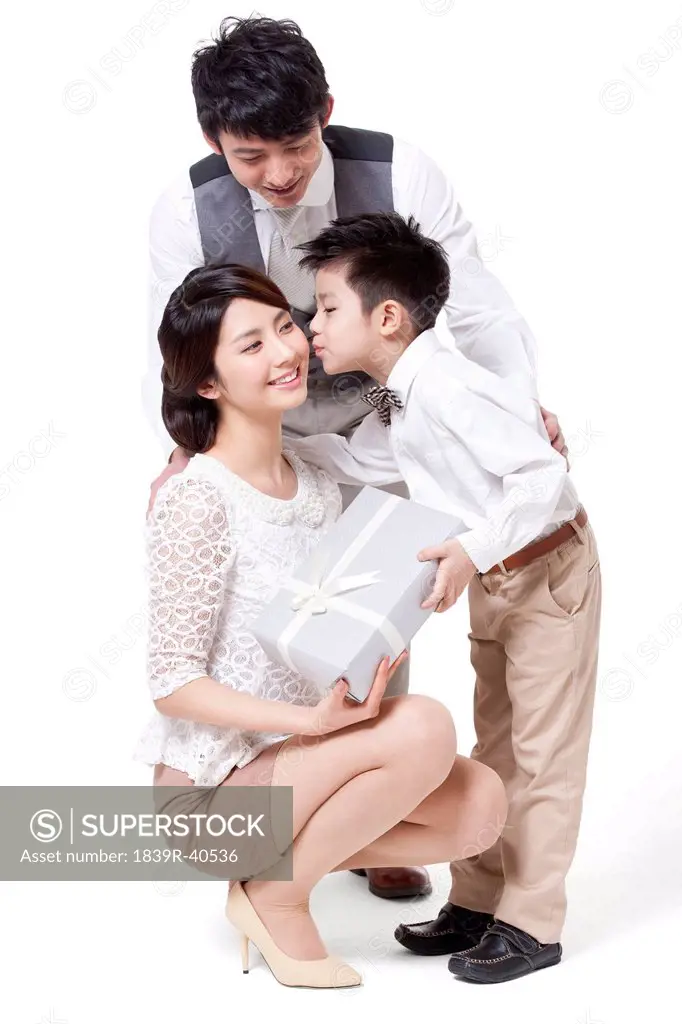 Happy young family sending gift and kissing