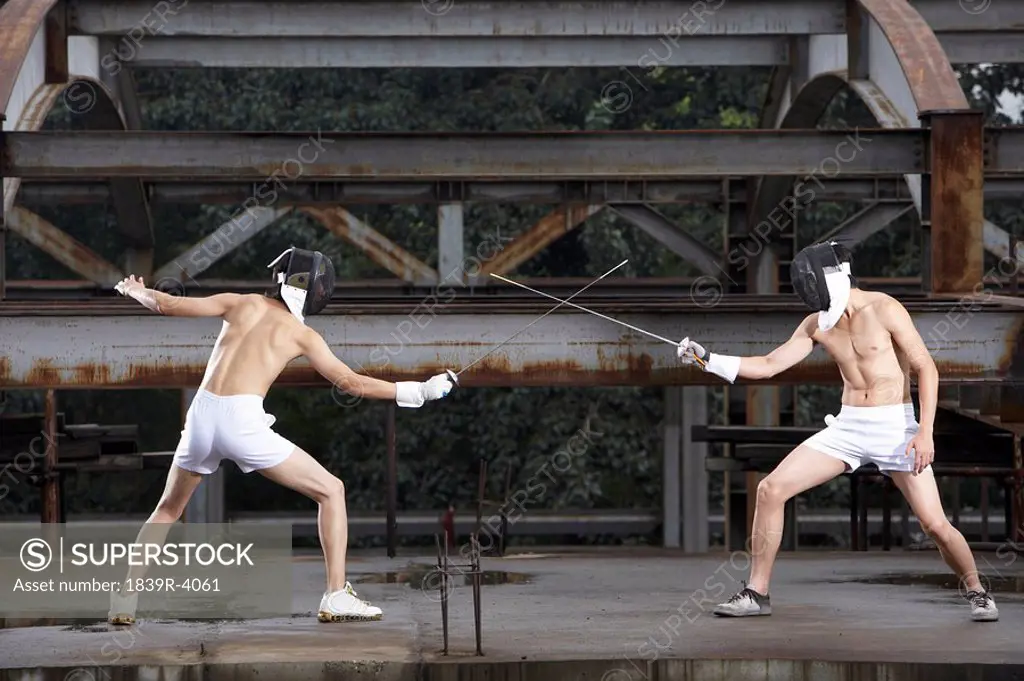 Young Men Fencing In Their Underwear In A Construction Site