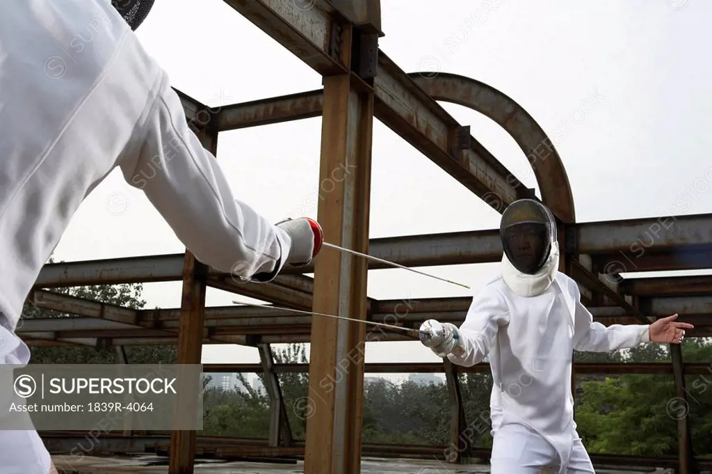 Young Men Fencing In A Construction Site